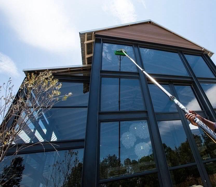 Water-fed pole window cleaning on a glass gable home